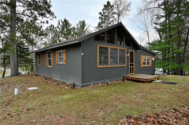 view of side of property featuring a yard and a wooden deck