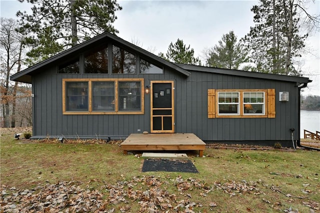 rear view of property featuring a lawn