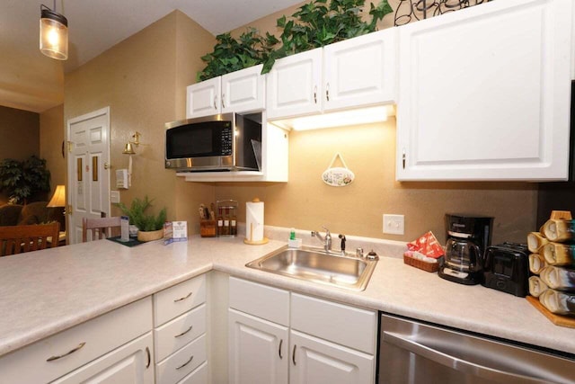 kitchen featuring appliances with stainless steel finishes, white cabinetry, hanging light fixtures, and sink