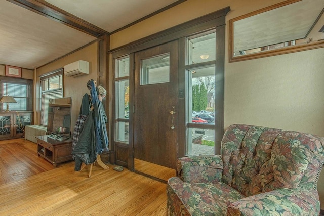 interior space featuring a wealth of natural light, light hardwood / wood-style flooring, crown molding, and a wall mounted air conditioner