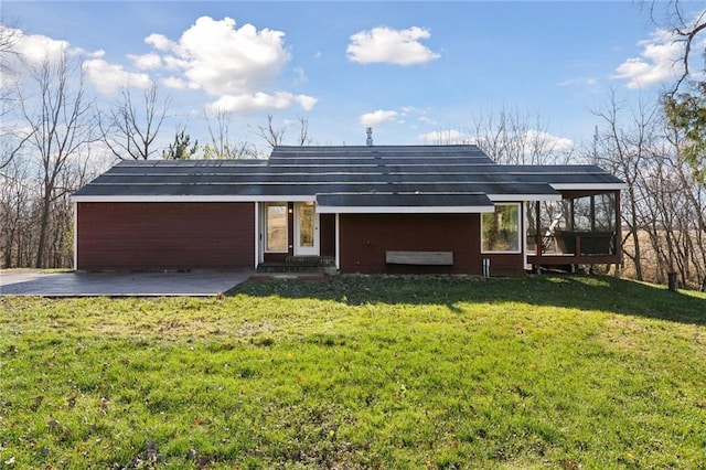 rear view of house with a lawn and a patio