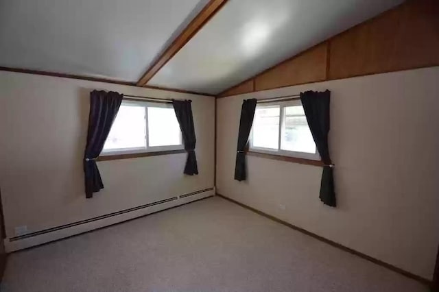 empty room with vaulted ceiling and a baseboard heating unit