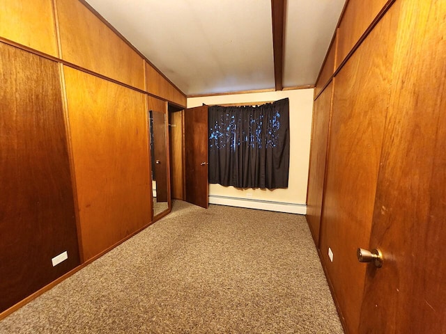 hall with wood walls, carpet floors, and a baseboard heating unit