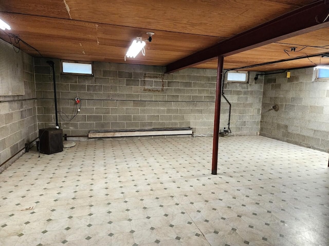 basement featuring wood ceiling and a baseboard heating unit