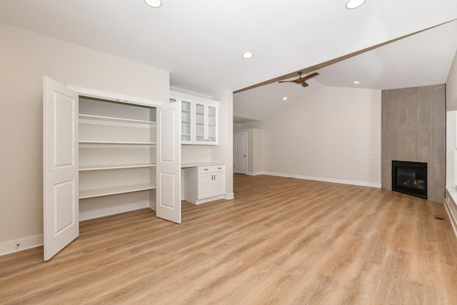 1411 Tamarack St, Delavan, WI 53115 - unfurnished living room featuring recessed lighting, light wood-type flooring, vaulted ceiling, and a tiled fireplace