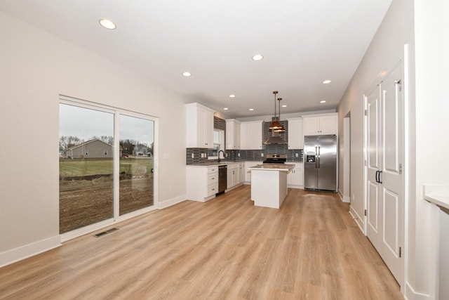 1411 Tamarack St, Delavan, WI 53115 - kitchen with stainless steel appliances, wall chimney range hood, light wood-style floors, white cabinetry, and recessed lighting