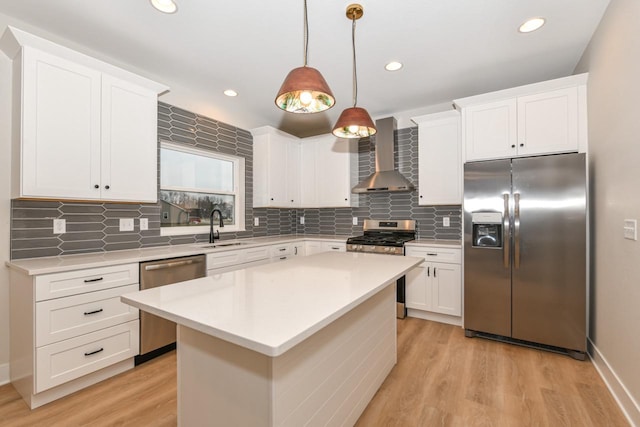 1411 Tamarack St, Delavan, WI 53115 - kitchen with stainless steel appliances, wall chimney exhaust hood, light wood-style flooring, light countertops, and a center island