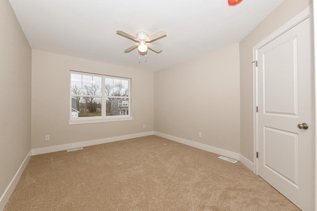 spare room featuring ceiling fan and light carpet