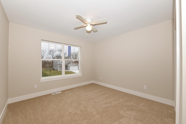 carpeted spare room with ceiling fan