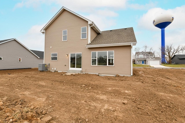 rear view of house with a garage and central air condition unit