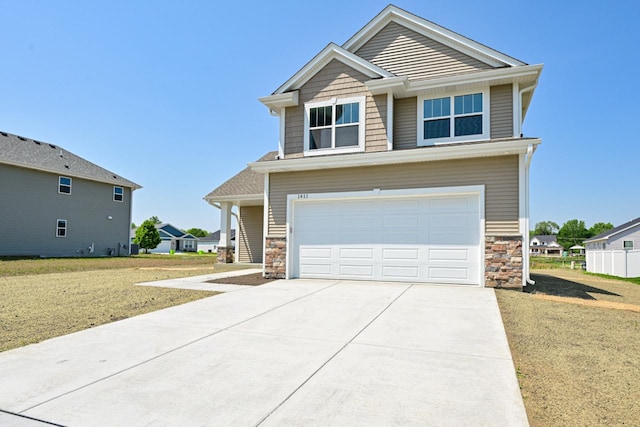 1411 Tamarack St, Delavan, WI 53115 - craftsman house featuring stone siding, concrete driveway, an attached garage, and a front lawn
