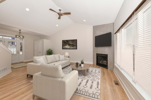 1411 Tamarack St, Delavan, WI 53115 - living room with lofted ceiling, a ceiling fan, light wood-style flooring, a large fireplace, and a chandelier