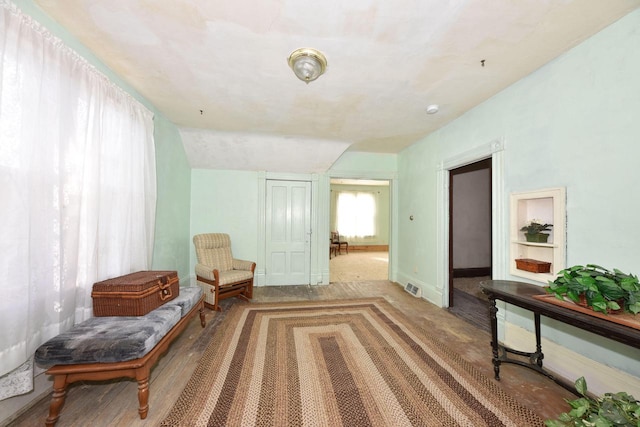 living area featuring vaulted ceiling and hardwood / wood-style flooring