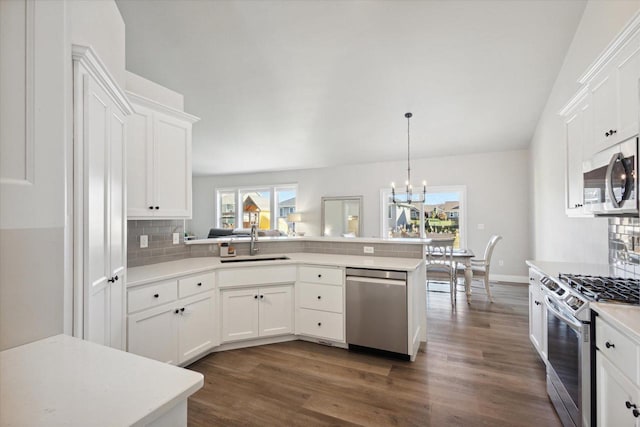7759 Sunstone Ct, De Pere, WI 54115 - kitchen with appliances with stainless steel finishes, a sink, light countertops, a peninsula, and dark wood-type flooring