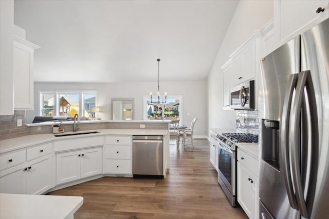 7759 Sunstone Ct, De Pere, WI 54115 - kitchen with appliances with stainless steel finishes, a sink, vaulted ceiling, tasteful backsplash, and a peninsula