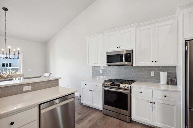 7759 Sunstone Ct, De Pere, WI 54115 - kitchen with appliances with stainless steel finishes, a chandelier, vaulted ceiling, backsplash, and wood finished floors