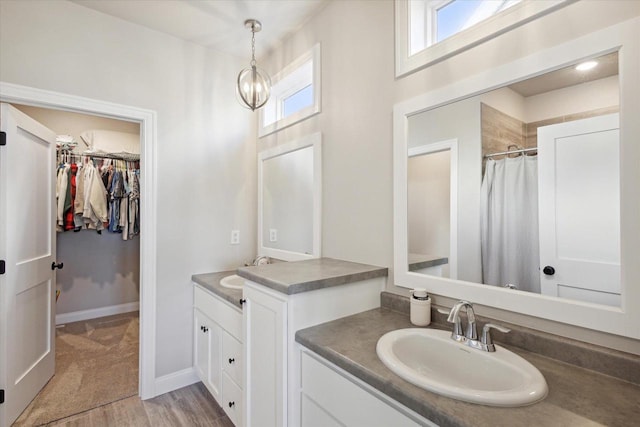 7759 Sunstone Ct, De Pere, WI 54115 - full bathroom with two vanities, wood finished floors, a spacious closet, and curtained shower