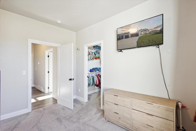 7759 Sunstone Ct, De Pere, WI 54115 - bedroom with a walk in closet, light colored carpet, a closet, and baseboards