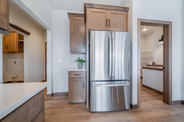 kitchen featuring stainless steel refrigerator and light hardwood / wood-style flooring