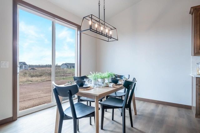 dining space featuring hardwood / wood-style floors and a notable chandelier