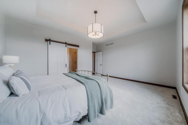 bedroom with a barn door and carpet floors