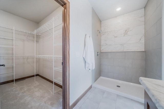 bathroom featuring vanity, tiled shower, and tile patterned floors