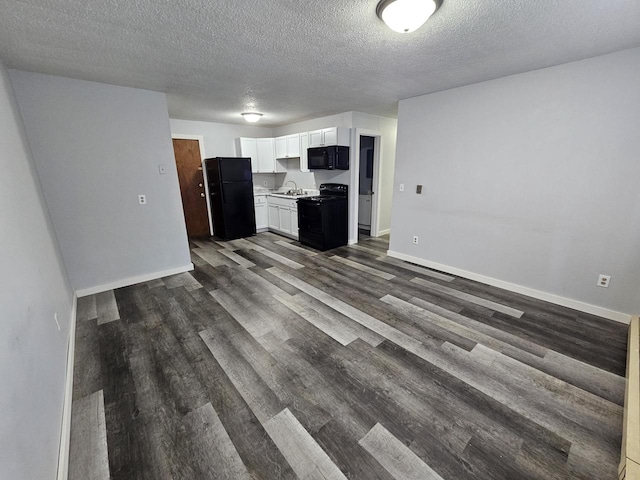 kitchen with white cabinetry, dark wood-type flooring, black appliances, and a textured ceiling