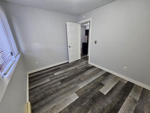 1160 Oakview Dr, Saint Charles, MN 55972 - empty room featuring dark wood-style flooring, baseboards, a textured ceiling, baseboard heating, and a smoke detector
