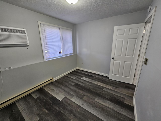 empty room featuring baseboard heating, a wall mounted AC, a textured ceiling, and dark hardwood / wood-style floors