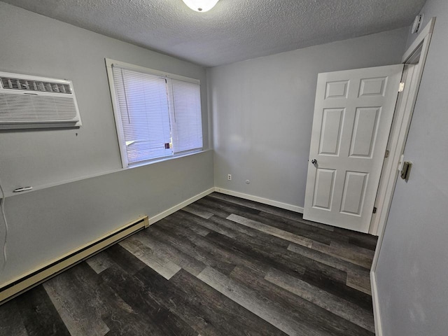 1160 Oakview Dr, Saint Charles, MN 55972 - unfurnished bedroom featuring a baseboard radiator, dark wood-style flooring, a textured ceiling, baseboards, and an AC wall unit