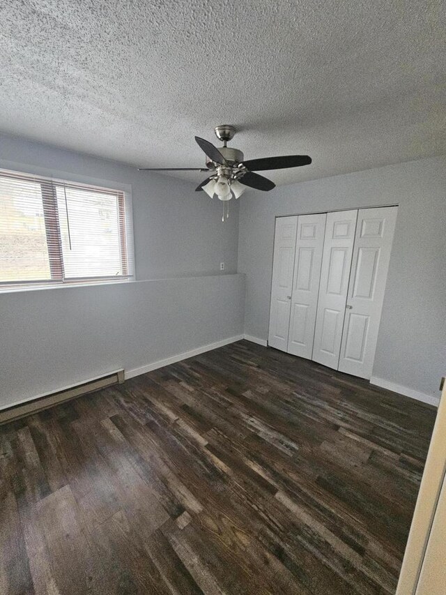 1160 Oakview Dr, Saint Charles, MN 55972 - unfurnished bedroom featuring dark wood-type flooring, a closet, baseboards, ceiling fan, and a textured ceiling
