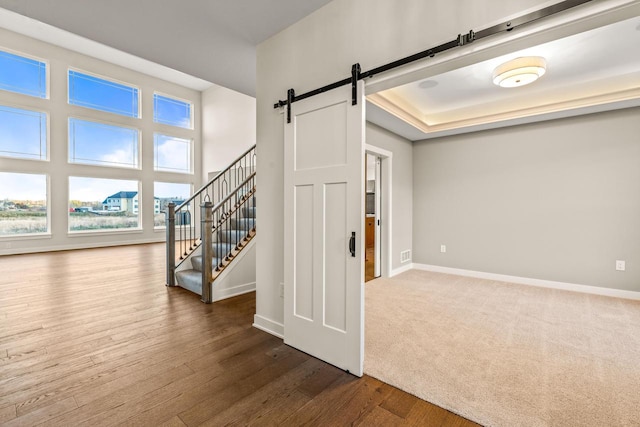 interior space with a barn door and wood-type flooring