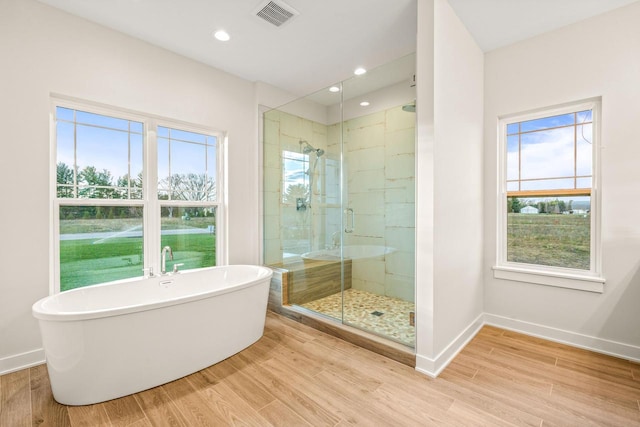 bathroom with plus walk in shower and hardwood / wood-style flooring