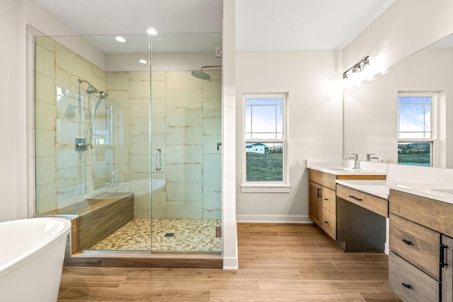 bathroom featuring hardwood / wood-style floors, vanity, a healthy amount of sunlight, and separate shower and tub