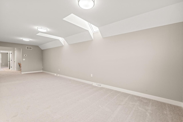 interior space featuring light colored carpet and vaulted ceiling