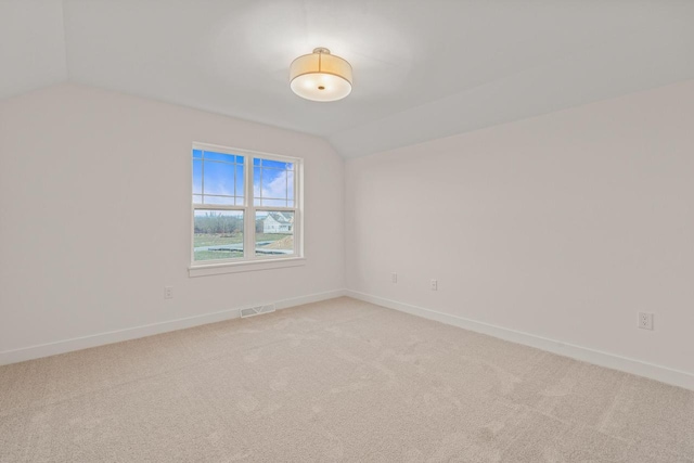 unfurnished room featuring carpet and vaulted ceiling