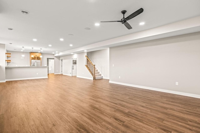 unfurnished living room featuring hardwood / wood-style flooring and ceiling fan