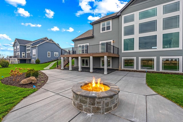 back of house with a yard, a fire pit, and a deck