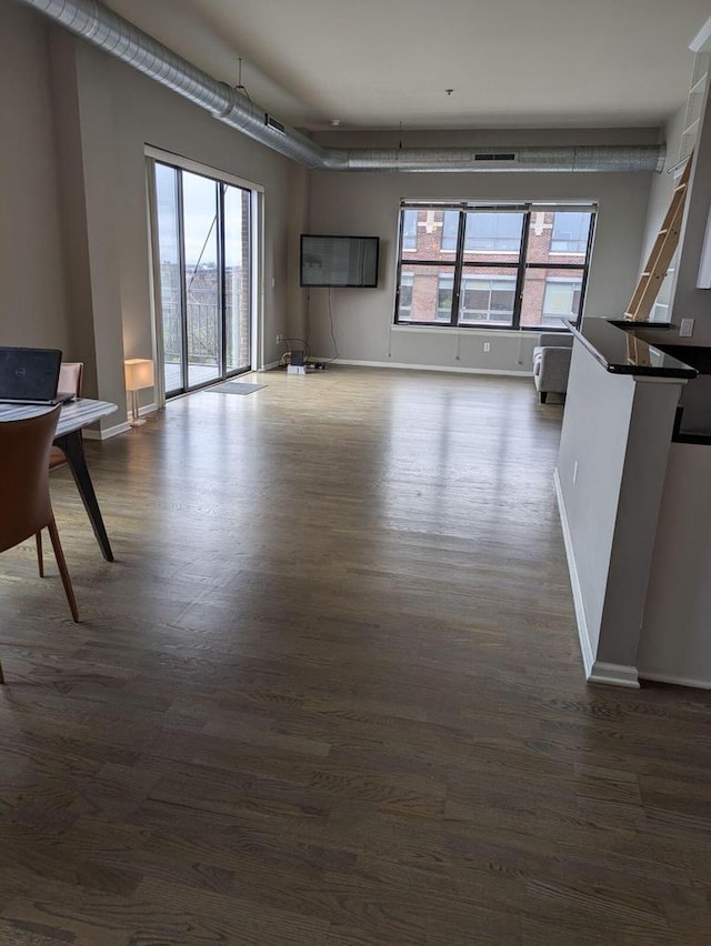 unfurnished living room with dark wood-type flooring