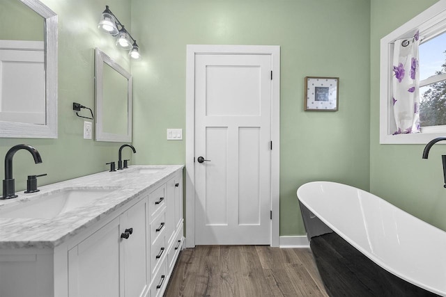 bathroom with hardwood / wood-style floors, vanity, and a bathing tub