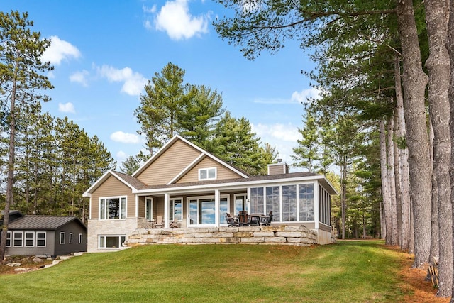 back of property featuring a lawn and a sunroom