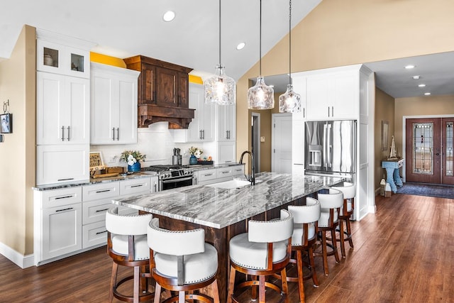 kitchen featuring white cabinets, pendant lighting, a kitchen island with sink, dark hardwood / wood-style flooring, and stainless steel appliances