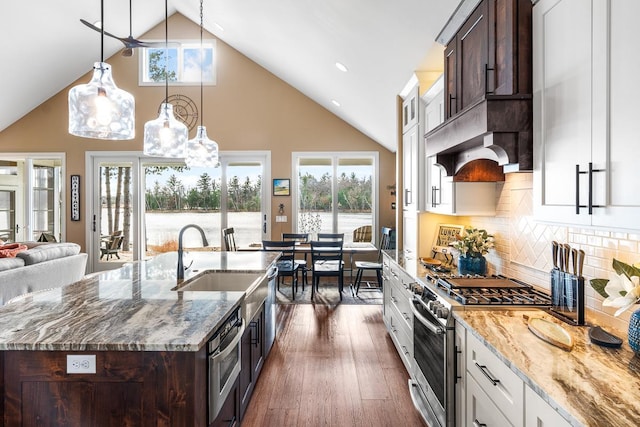 kitchen featuring white cabinets, decorative light fixtures, stainless steel appliances, and plenty of natural light