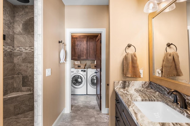 bathroom featuring independent washer and dryer, tiled shower, and vanity