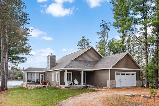 view of front of property featuring a front yard, a porch, a garage, and a sunroom