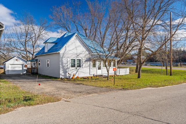 view of front of house with an outbuilding, a garage, and a front lawn