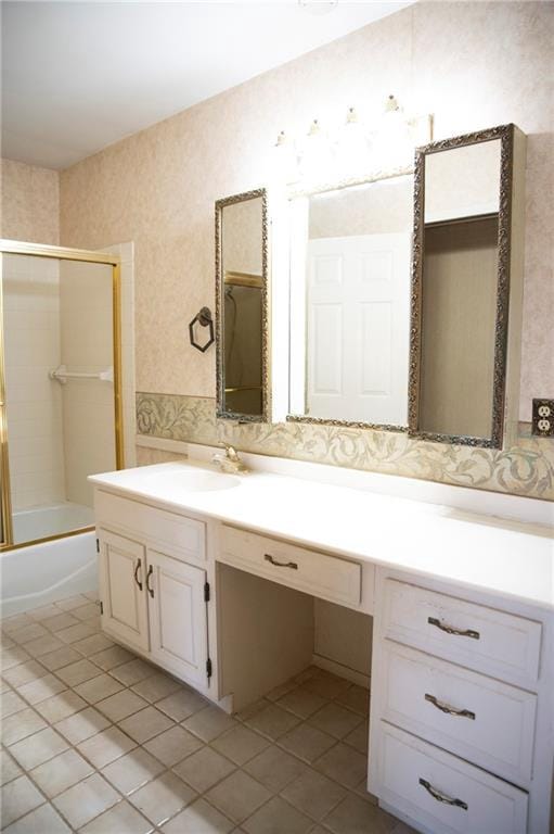 bathroom with tile patterned flooring, vanity, and enclosed tub / shower combo