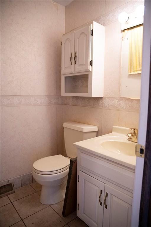 bathroom featuring tile patterned flooring, vanity, toilet, and tile walls