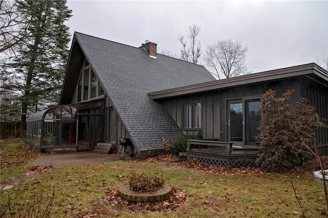 back of house with a lawn and a sunroom