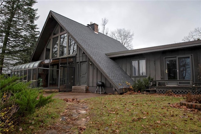 rear view of property with a sunroom and a yard